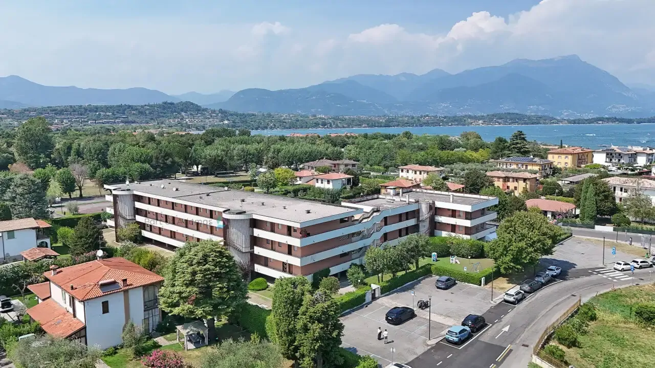 Aerial view of residential complex with parking and greenery