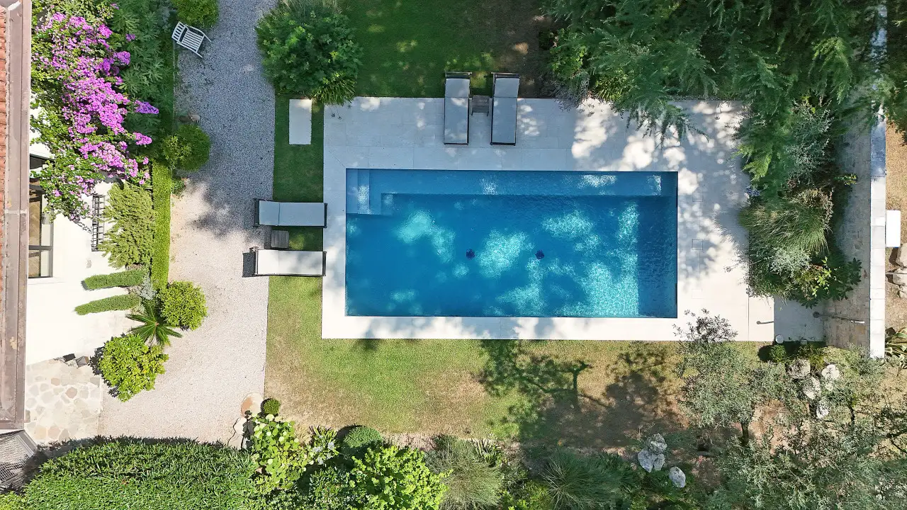 Rechteckiger Pool mit Steinrand und Liegestühlen