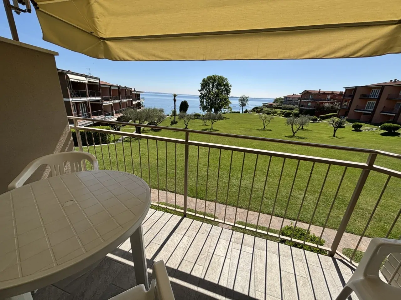 Terrazza con tavolo e sedie con vista sul giardino e lago