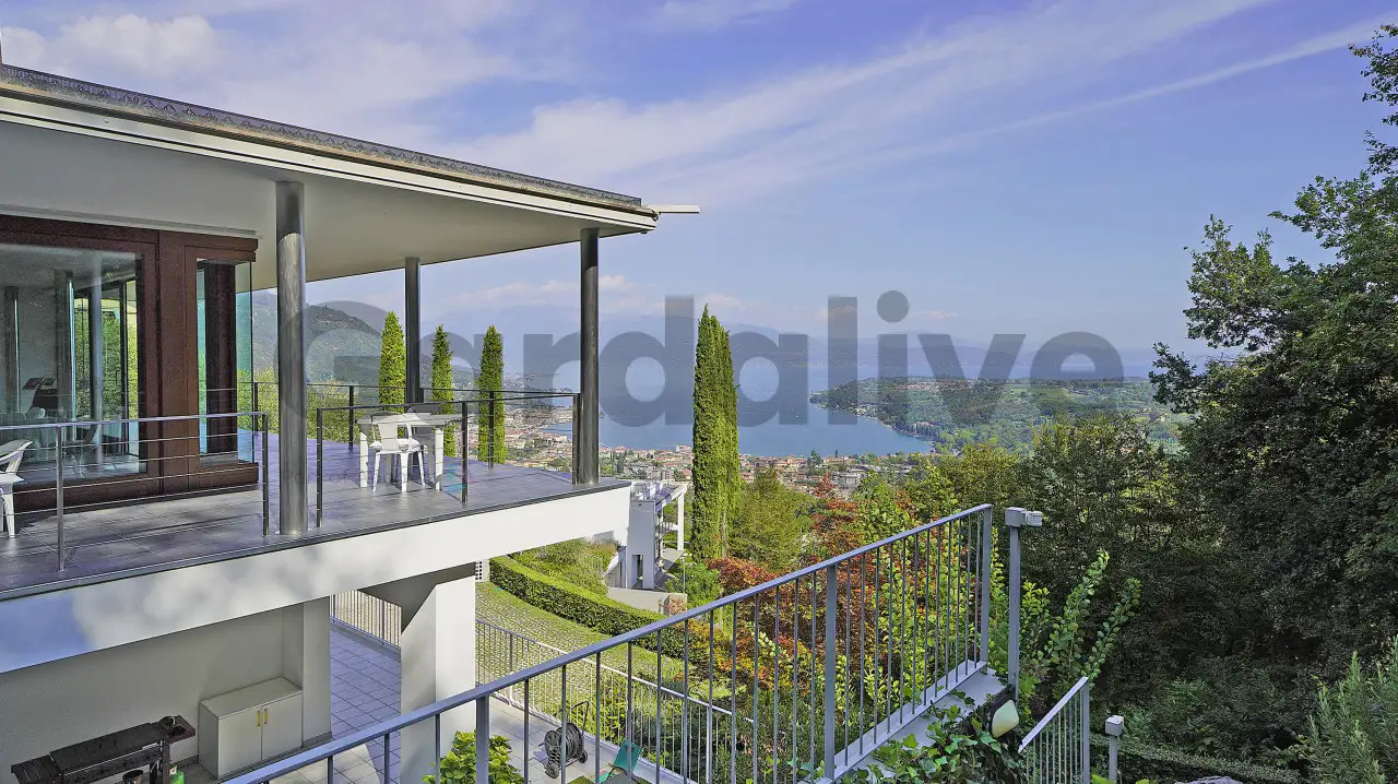 Terrasse mit Geländer und Blick auf den See und die grüne Landschaft