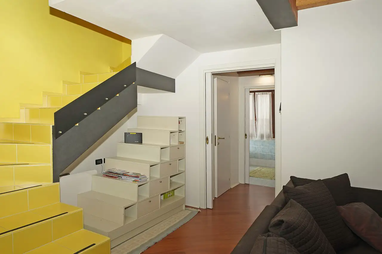 Wohnzimmer mit Sofa und gelber Innentreppe