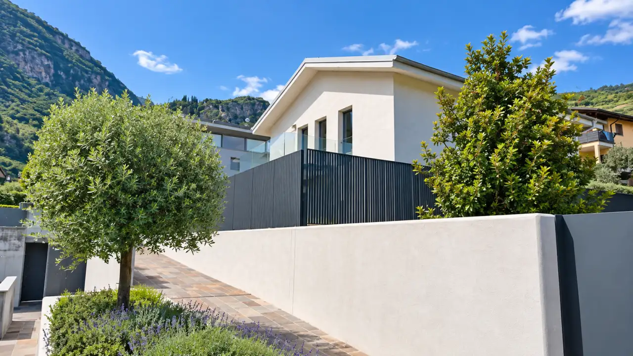 Außenansicht der Villa mit weißer Mauer und Bäumen