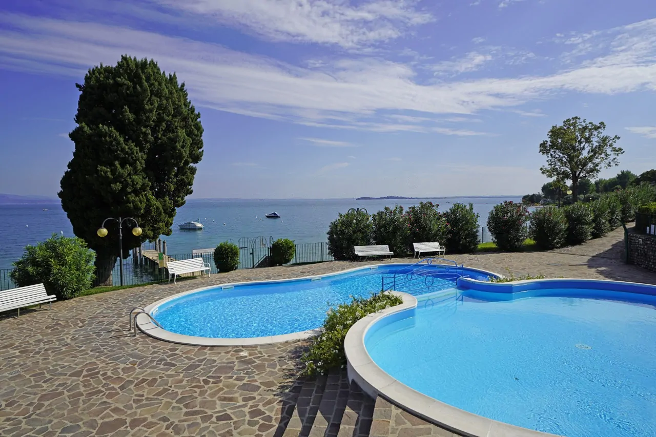 Piscina privata con bordo in pietra e vista lago