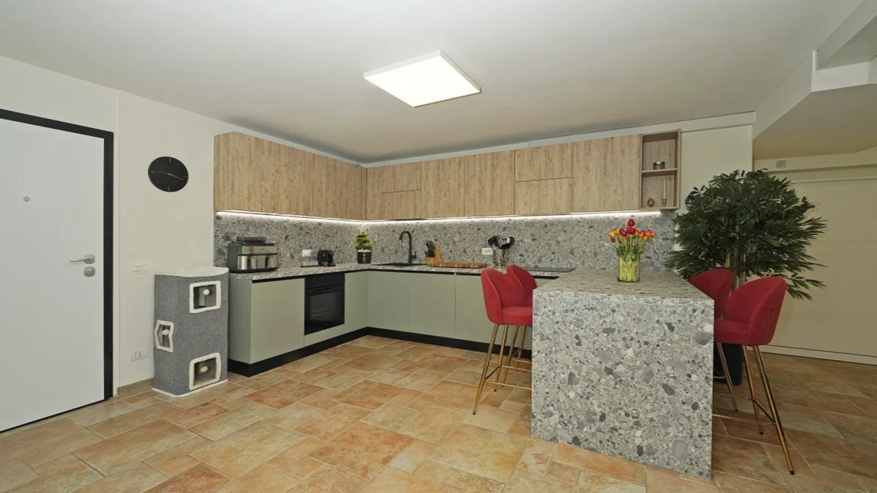 Cucina angolare con isola e sgabelli rossi