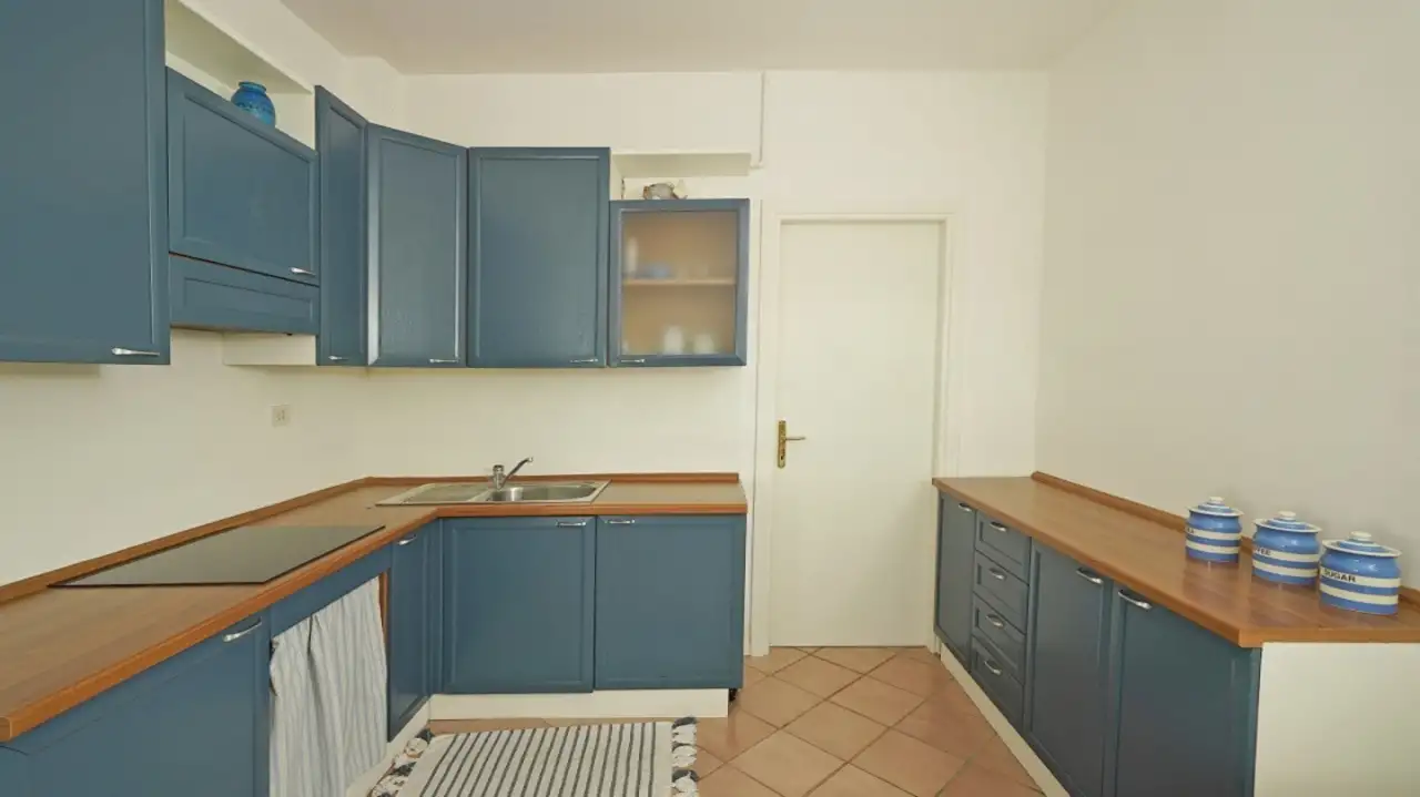 Cucina con mobili blu e piano in legno