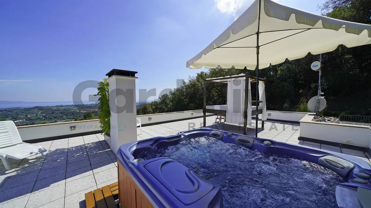Terrasse mit Whirlpool und weißem Sonnenschirm