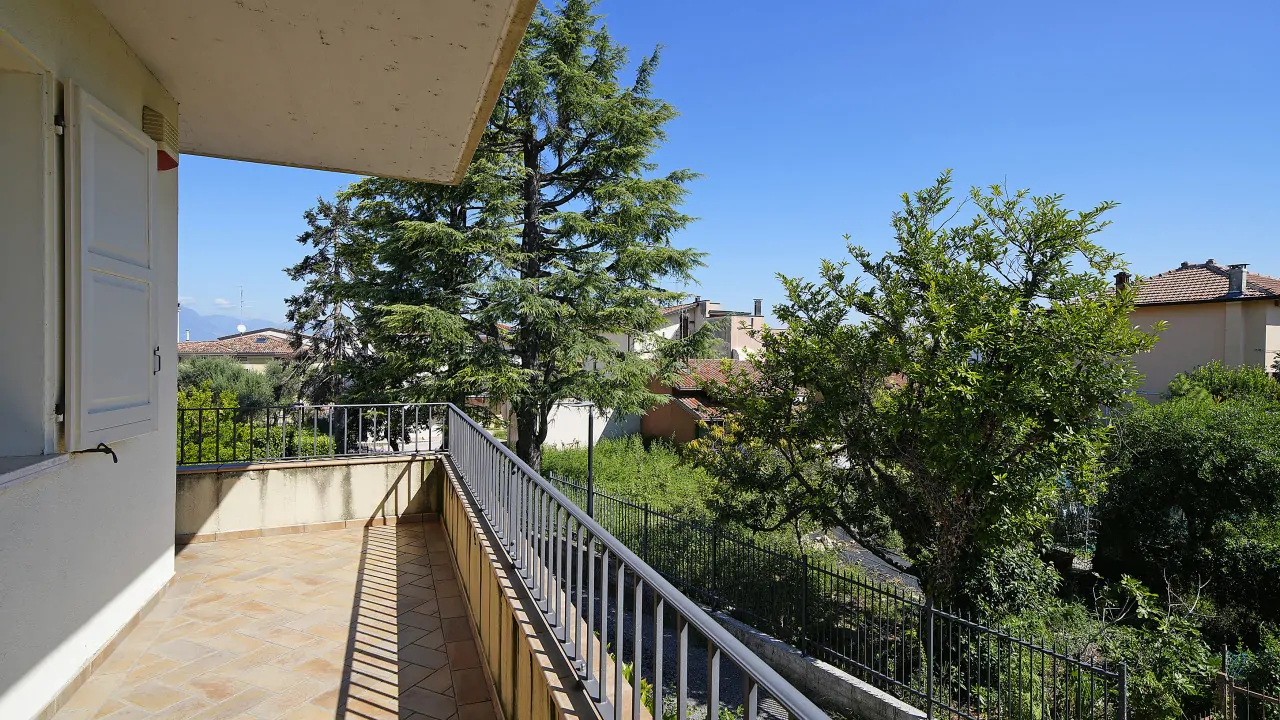 Terrasse mit Geländer und Blick auf Bäume und nahegelegene Häuser