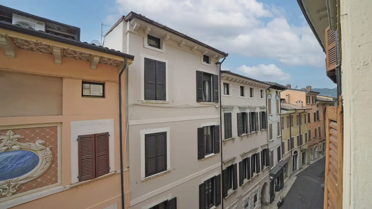 Vista su strada storica con edifici e persiane chiuse