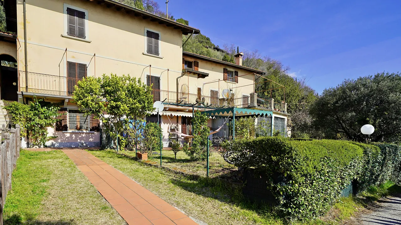 Hausfassade mit Garten und gepflegter Hecke