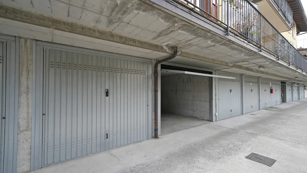 Autorimessa doppia con porte grigie e pavimento in cemento