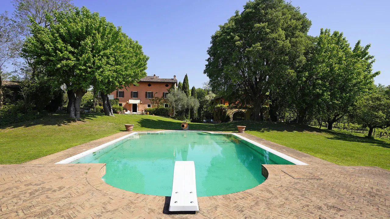 Rectangular swimming pool with diving board and surrounding green lawn