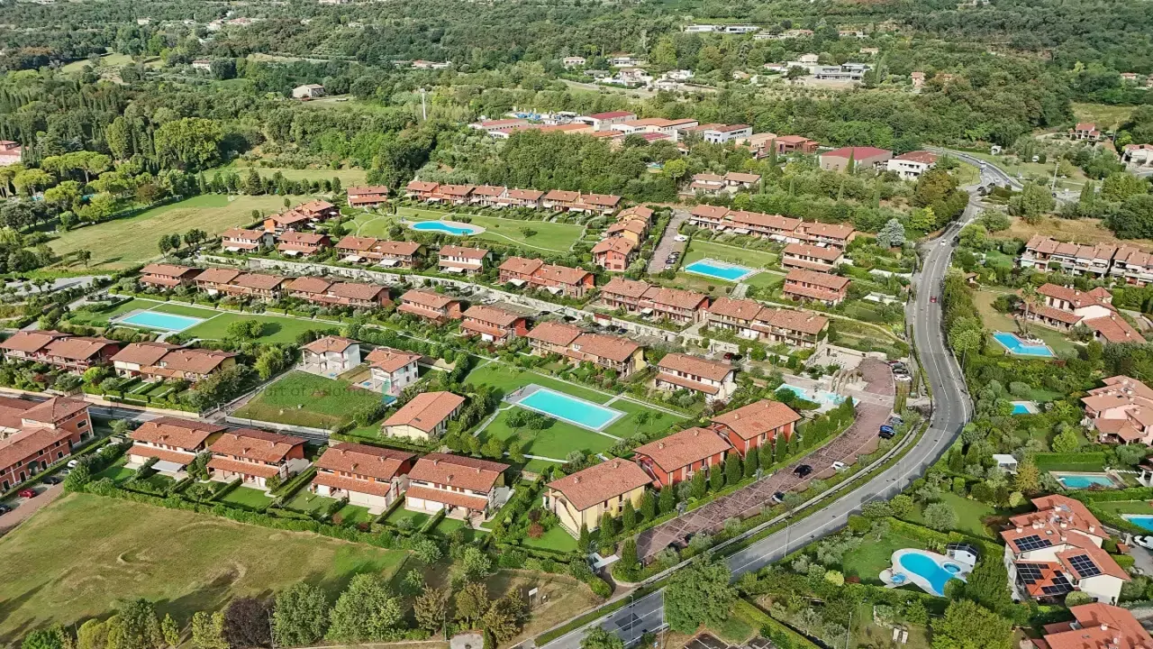 Veduta aerea del complesso residenziale con piscine e giardini a Padenghe sul Garda