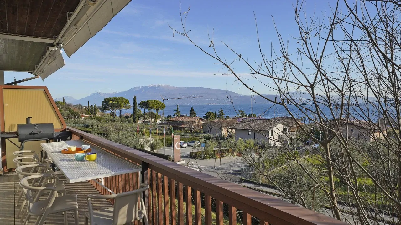 Terrace with table and chairs overlooking lake and mountains