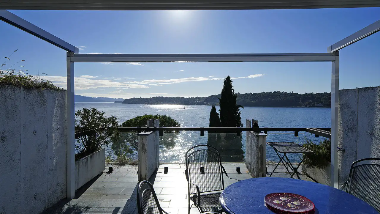 Terrasse mit Tisch und Stühlen und Seeblick