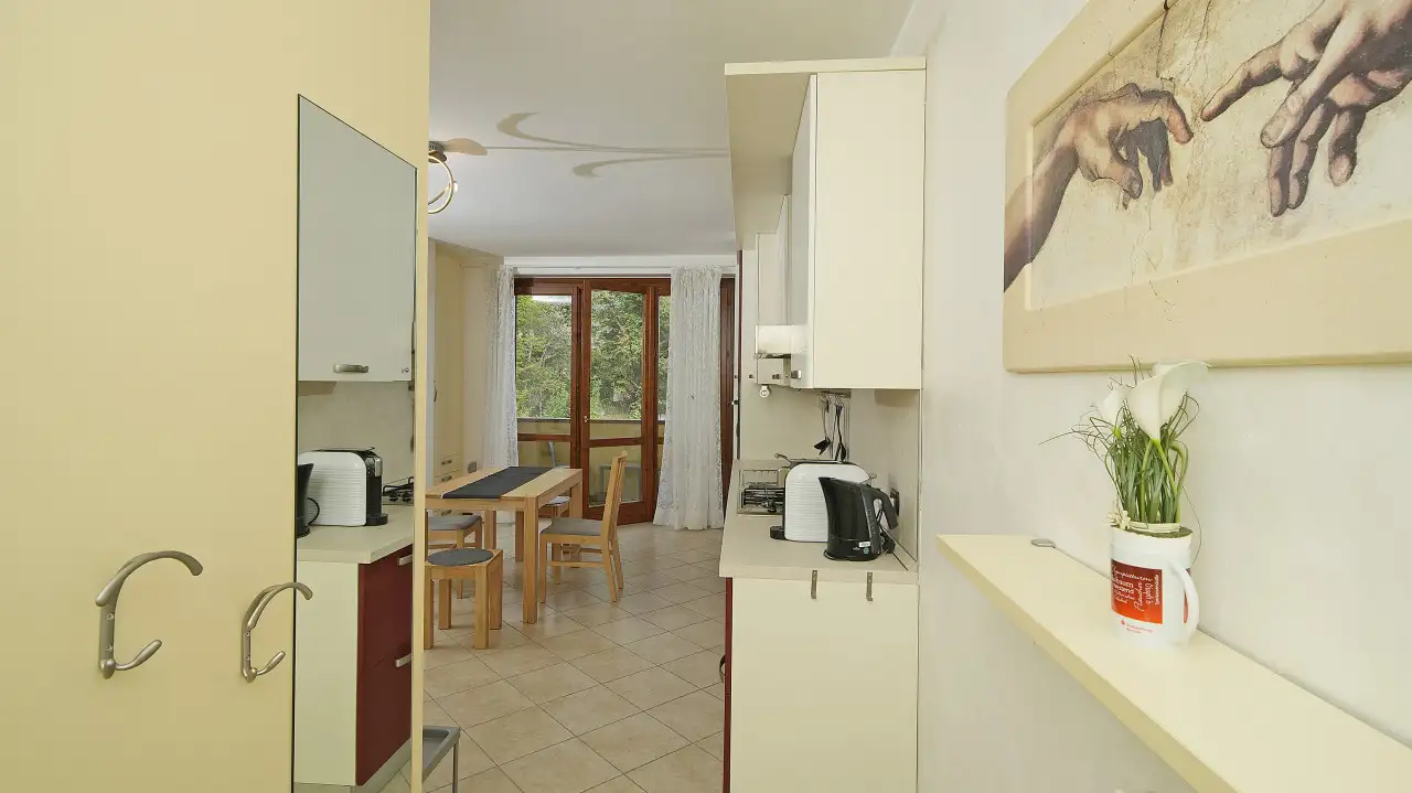 Cucina con tavolo e porta finestra sul balcone