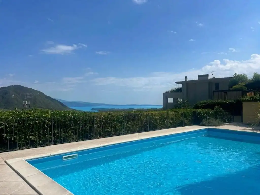 Schwimmbad mit Blick auf See und Hügel