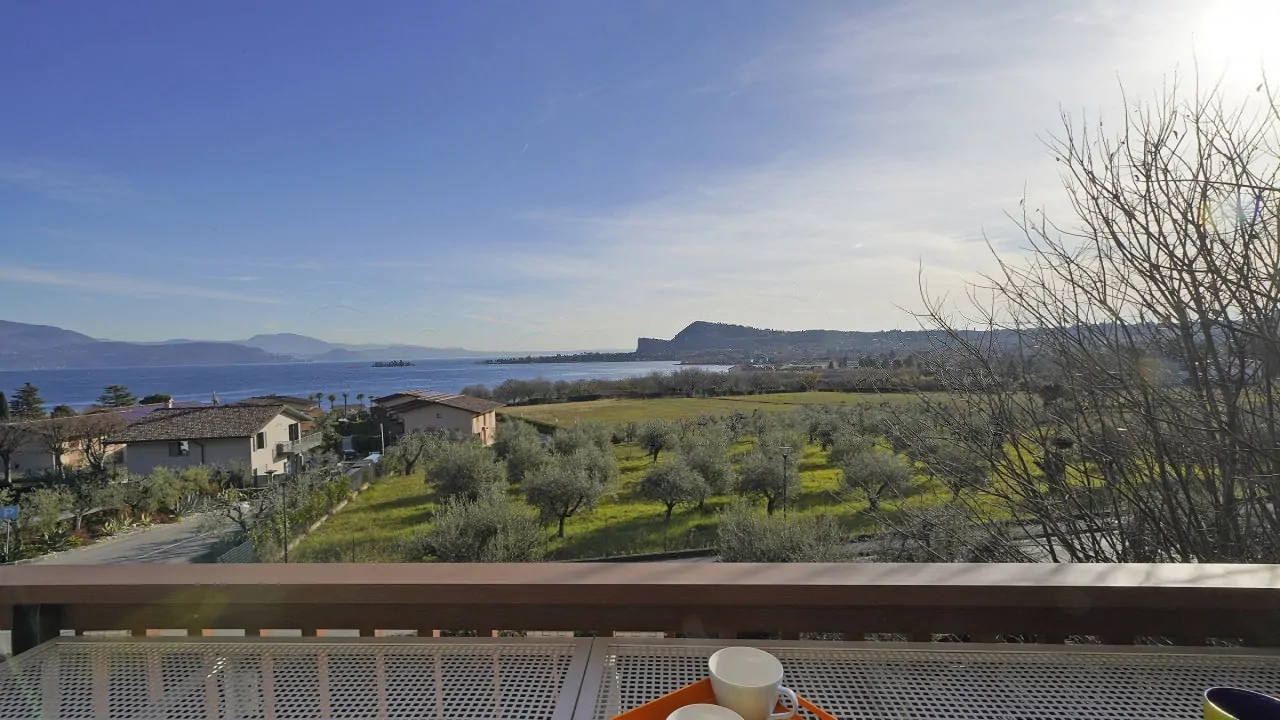 Lake and fields view from terrace with table and cups