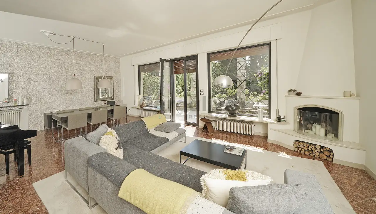 Wohnzimmer mit grauem Sofa und weißem Kamin