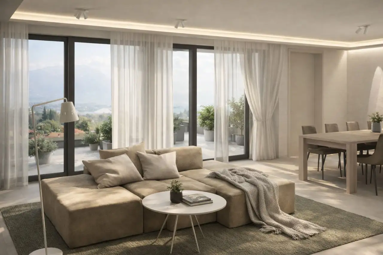 Living room with sofa and coffee table in front of large windows with sheer curtains
