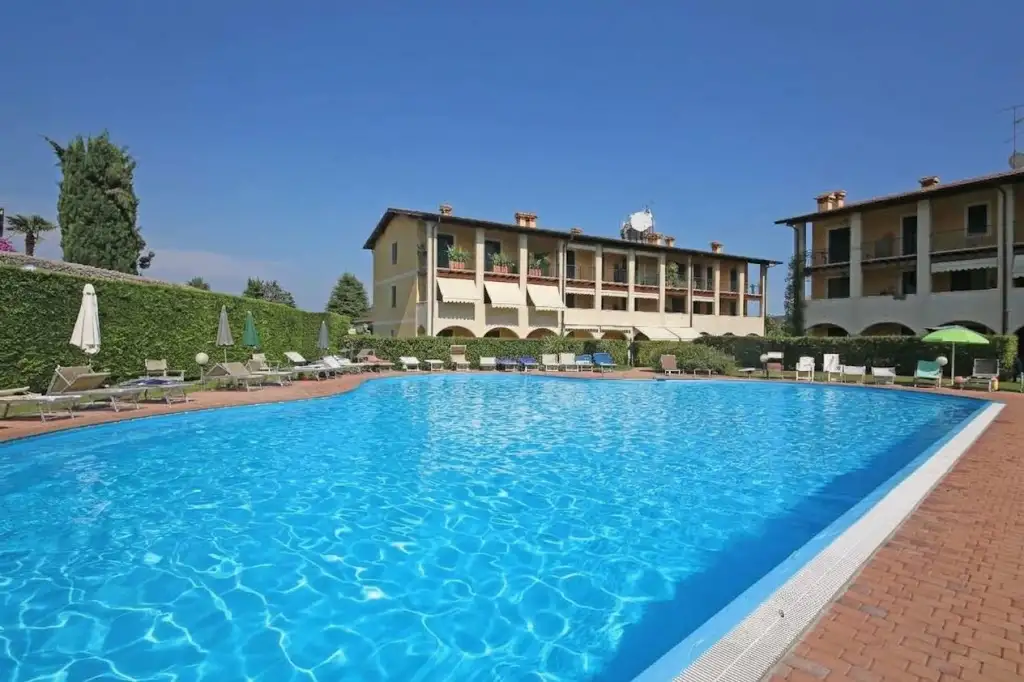 Outdoor pool with brick edge and sun loungers